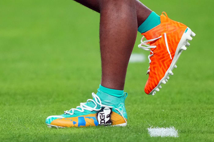 Miami Dolphins quarterback Tua Tagovailoa's green and orange adidas cleats.